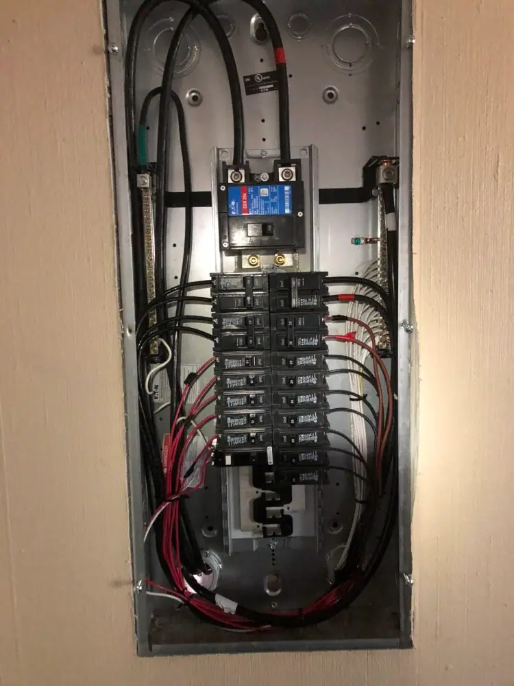Open residential breaker panel showing breakers and wiring